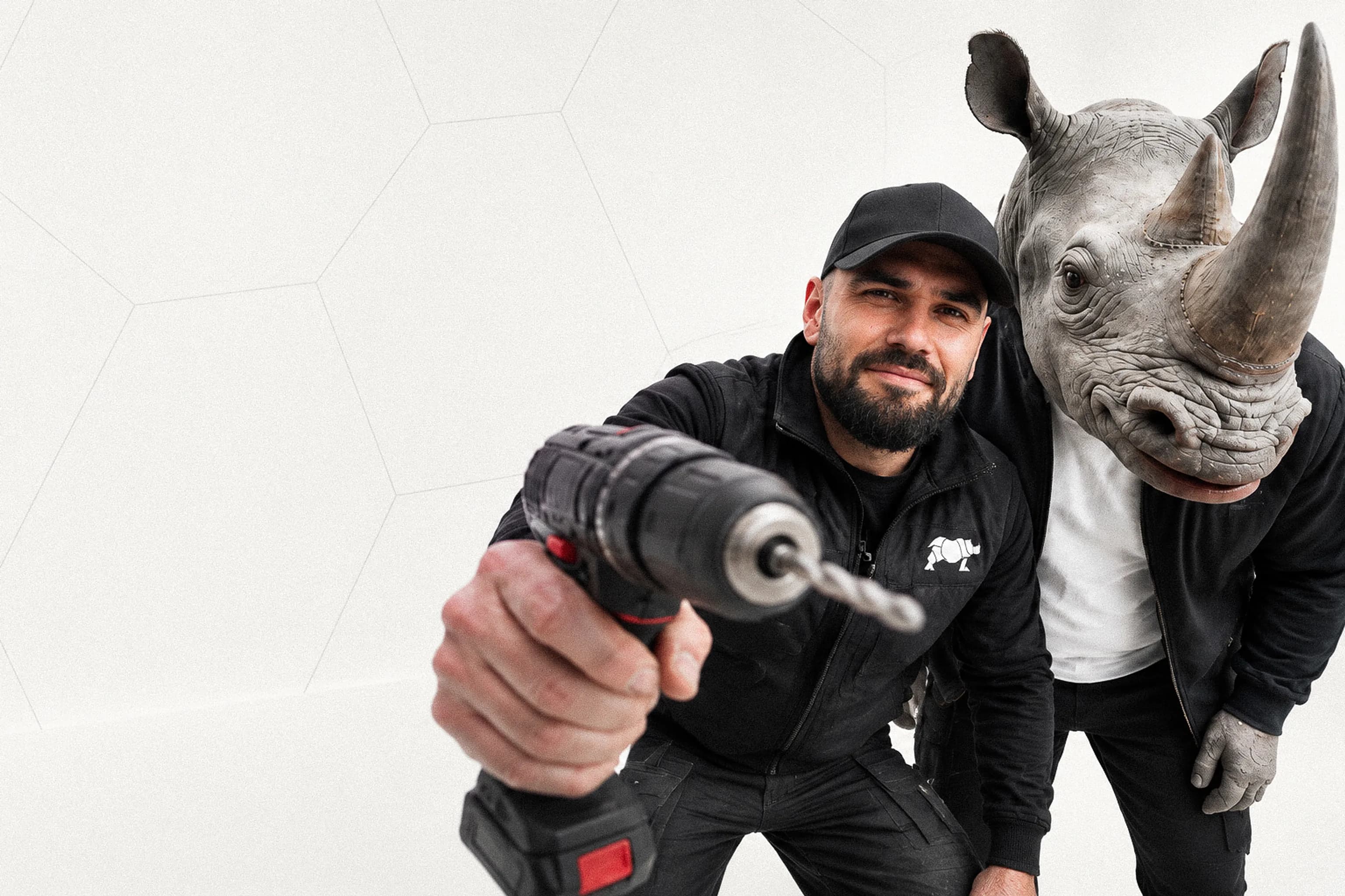 Programme secteur bâtiment : un professionnel tend sa perceuse vers l’objectif, à côté d’un personnage à tête de rhinocéros